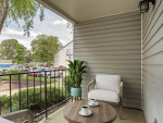 Cozy patio with seating and coffee cups, ideal for relaxing in renovated apartments near shopping.