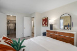 Stylish bedroom with hardwood flooring, walk-in closet, and modern decor at Independence Green Apartments