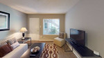Spacious living room in a Memphis apartment featuring central air, updated flooring, and modern decor.