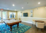 Resident lounge area with pool table and seating at Rose Heights Apartments in Raleigh, NC