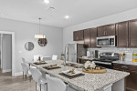 Modern kitchen in an apartment featuring granite countertops, stainless steel appliances, and stylish decor.