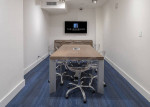 Modern conference room at The Residences at Merrick Park with a large table and a screen for presentations.
