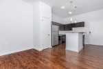 Modern apartment interior at C Street Flats featuring a kitchen and living area with hardwood floors.