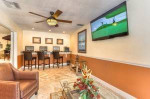 Cozy business center with computers, comfortable seating, and a TV in a charming apartment community.