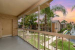 Charming 1x1 apartment balcony view in sunny Fort Myers, featuring palm trees and community amenities.