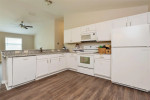 Modern kitchen of a 2013 villa in The Villages, featuring white cabinetry and granite countertops.