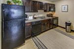 Modern kitchen with black appliances, including dishwasher and refrigerator, in furnished Plattsburgh apartment