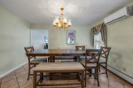 Bright dining room with wooden table, chairs, and chandelier in Brooklyn single family home for sale.