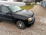 2005 Chevrolet TrailBlazer parked on gravel, features a black exterior and is maintained for reliability.