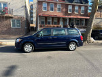 2012 Dodge Grand Caravan parked on street with clean exterior, suitable for families or cargo.
