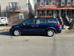 2012 Dodge Grand Caravan in blue color, side view parked on the street, low mileage at 97k, family-friendly minivan.