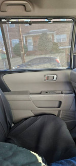Interior view of a 2013 Honda Pilot Touring showing seating and door features, ideal for families.