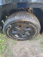 Close-up view of a black wheel and tire of a 2007 Avalanche for trade or sale
