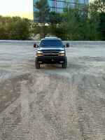 Front view of a 2006 Chevrolet Silverado 1500 truck with 116,000 miles, parked on gravel