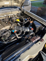 Engine compartment of a 2003 Nissan Xterra for sale, showing components and condition for repair or parts.