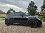 2013 Mini Cooper S Turbo in black parked on a paved driveway, showcasing sleek design and modern features.