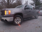2012 GMC Sierra 4x4 Xtra cab truck with 58,600 miles parked on a gravel road.