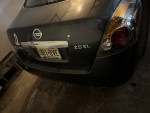 Rear view of a 2012 Nissan Altima SL parked in a garage with a license plate.