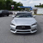 Silver INFINITI Q60 Coupe parked on a street, showcasing its sleek design and prominent front grille.