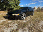 1994 Ford Mustang Cobra in black, showing good condition with low miles and aftermarket supercharger.