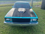 Front view of a 1978 Chevrolet Malibu Custom Wagon in teal and black with a sleek design.