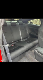 Interior view of the backseat in a 2017 Honda Civic EX, featuring black upholstery and seat belts.