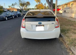 Rear view of a 2012 Toyota Prius Four parked on the street, showcasing its clean condition and hybrid design.