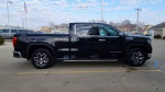 2023 GMC Sierra 1500 black truck parked with a clear sky in the background, available for sale.