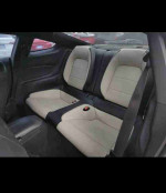 Interior view of 2015 Ford Mustang EcoBoost Premium back seats with beige and black upholstery.
