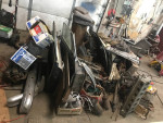 Collection of parts and components from a 1959 Jaguar XK150 drophead coupe in a garage setting.