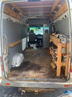 Interior view of a 2006 Dodge Sprinter 2500 van showing wood shelving and workspace.