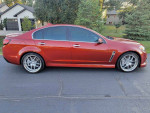 2015 Chevrolet SS sedan in red, showcasing sporty design and features like alloy wheels and sunroof.