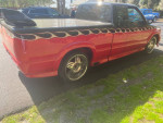 Custom 1995 Chevrolet S-10 Xtreme with flames and shiny wheels parked outdoors