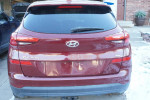 Rear view of a 2019 Hyundai Tucson SE FWD in maroon color parked outside, showcasing its sleek design.