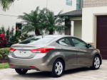 2012 Hyundai Elantra SE in excellent condition, grey metallic finish parked with palm trees in the background.