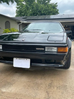 Front view of a beautifully restored 1985 Toyota Supra with new paint and interior, ready to impress at car shows.