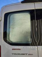 Rear view of a Ford Transit 250 van featuring an insulated window, ideal for temperature control during transport.
