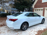 White 2017 Acura TLX Technology Package parked in a residential driveway, showcasing its sleek design.