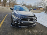 Front view of a 2021 Honda Civic EX in black, parked in a snowy area with trees in the background.