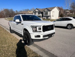 2020 Ford F150 Lariat in white, showcasing sleek design and features, parked on a residential street.