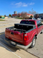 2001 Ford Sport Trac red pickup truck, well-maintained work vehicle with some dents and scratches.