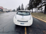 Rear view of a 2013 Nissan LEAF SL parked, showcasing its spacious hatchback and eco-friendly design.