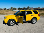 2011 yellow Ford Escape parked, showcasing its spacious interior and low mileage of 105,000 miles.