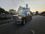 2022 Ford F250 Lariat Super Duty 4x4 parked on city street at sunset, showcasing its luxurious design and power.