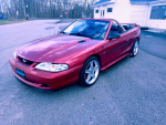 1995 Ford Mustang GT convertible, immaculate condition, red color, parked on the street.