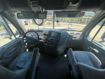 Interior view of a 2016 Freightliner Cascadia sleeper truck, showcasing controls and seating.