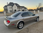 Beautiful silver Nissan Maxima SE parked in front of a large house, showcasing its clean lines and excellent condition.