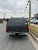 Rear view of a Chevrolet Suburban parked on the street, showcasing its clean condition and reliable performance.