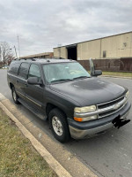 Chevrolet Suburban parked by the roadside, showing wear but in reliable condition, ready for sale.