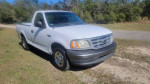2001 Ford F150 regular cab with 81,500 miles, white truck parked on grass.